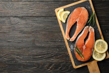 Ahşap arka planda somon eti ve baharatlı kompozisyon.