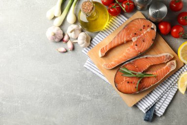 Gri arka planda somon eti ve malzemeli kompozisyon, üst görünüm