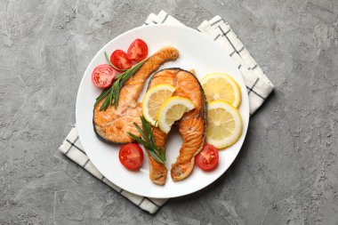 Gri arka planda lezzetli ızgara somon balığı kompozisyonu.