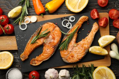 Ahşap arka planda lezzetli ızgara somon balığı kompozisyonu.