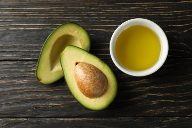 Olgun taze avokado ve ahşap arka planda yağ, üst manzara.