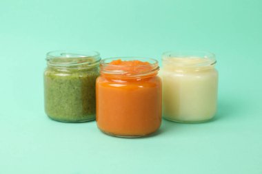 Naneli arkaplanda sebze püresi olan cam kavanozlar. Bebek maması.