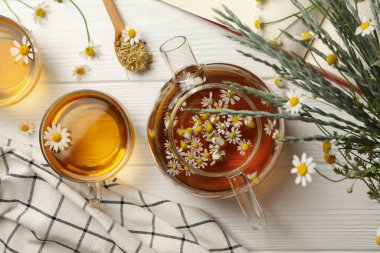 Beyaz ahşap arka planda papatya çayı ile kompozisyon