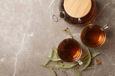 Gri arka planda ıhlamur çaylı kompozisyon, üst manzara. Doğal çay.