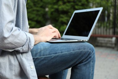 Dışarıda dizüstü bilgisayarda çalışan genç bir öğrenci. Çalış. Üniversite