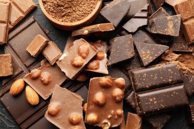 Çikolata, erimiş çikolata ve siyah arka planda badem.