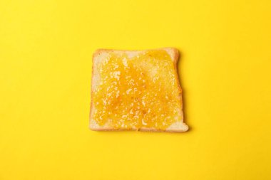 Sarı arka planda turuncu reçelli tost.
