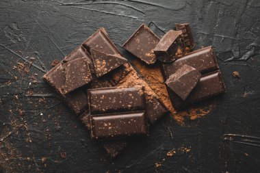 Siyah arka planda lezzetli çikolata ve pudra.