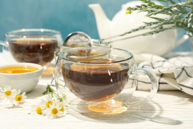 Beyaz ahşap masada papatya çayı ile kompozisyon