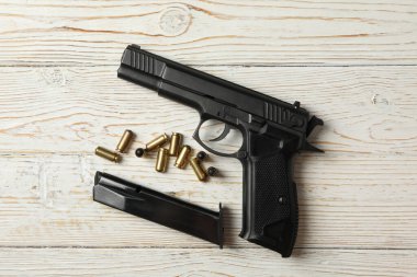 Ahşap arka planda tabanca, mermi ve şarjör