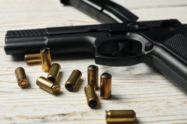 Ahşap arka planda tabanca, mermi ve şarjör