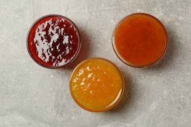 Gri arka planda reçelli kaseler, üst görünüm