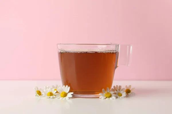 Tasse Tee Und Kamille Auf Weißem Tisch Vor Rosa Hintergrund — Stockfoto