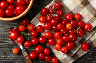 Havlu, kaşık ve kase, ahşap arka planda kiraz, üst manzara.