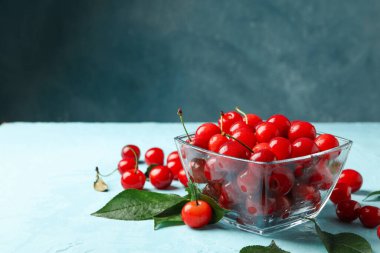 Mavi arkaplanda kırmızı kirazlı kase, metin için boşluk