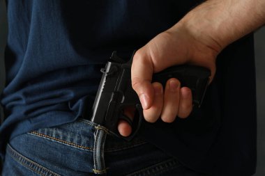 Bir adam arkadan silah tutuyor. Nefsi müdafaa