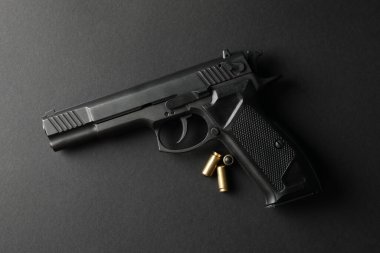 Siyah arka planda tabanca ve travmatik mermiler. Nefsi müdafaa
