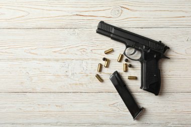 Ahşap arka planda tabanca, mermi ve şarjör