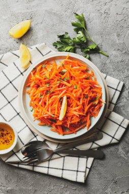 Gri arka planda lezzetli havuç salatası kompozisyonu. Kore havucu