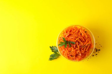 Sarı arka planda havuç salatası olan bir kase. Kore yemeği.