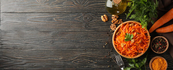 Composition with tasty carrot salad on wooden background. Korean carrot