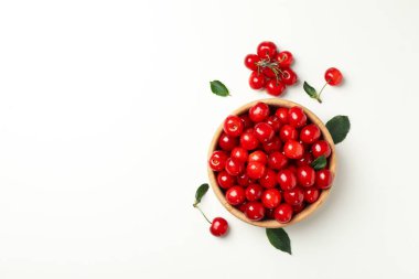 Beyaz arka planda taze kırmızı kirazlı kase, üst manzara.