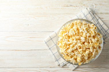 Beyaz ahşap arka planda patlamış mısır kasesi. Sinema izlemek için yiyecek.