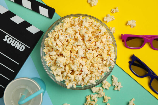 Composition with bowl of popcorn on multicolor background