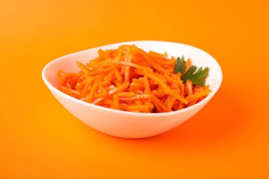 Turuncu arka planda havuç salatası olan kase, kapat.