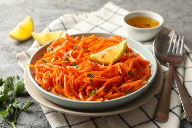 Gri arka planda lezzetli havuç salatası kompozisyonu. Kore havucu