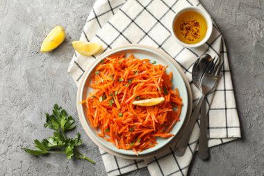 Gri arka planda lezzetli havuç salatası kompozisyonu. Kore havucu