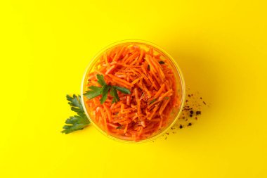 Sarı arka planda havuç salatası olan bir kase. Kore yemeği.