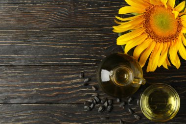 Ahşap zemin üzerinde ayçiçeği, yağ ve tohumlarla kompozisyon