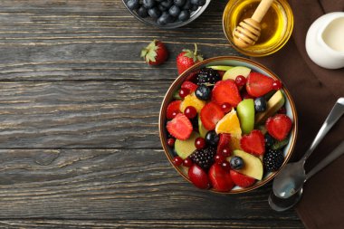 Ahşap arka planda taze meyve salatası ile kompozisyon, üst görünüm