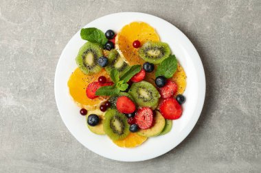 Gri arka planda taze meyve salatası, üst manzara.