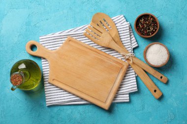 Mutfak çatal bıçak takımı, yağ ve baharatlar mavi arka planda, üst manzara