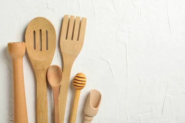 Wooden kitchen cutlery on white background, space for text