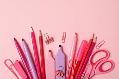 Pembe arka planda farklı malzemeler olan pembe kalem kutusu.