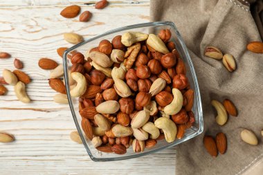 Beyaz ahşap arka planda farklı fındıklı kase