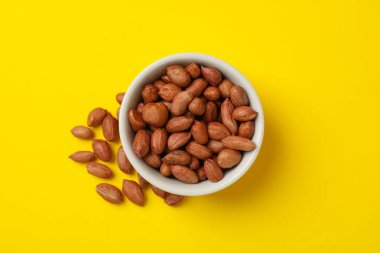 Sarı arka planda fıstıklı kase. Vitamin yiyeceği.