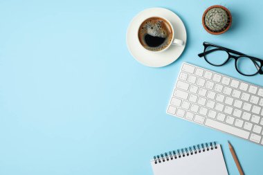 Mavi arka planda iş aksesuarları olan kompozisyon. Blogger çalışma alanı