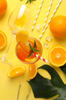 Sarı arka planda aperol spreyli kompozisyon