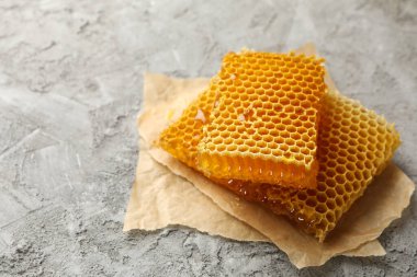 Gri zemin üzerinde bal peteği parçaları olan kağıt pişirme