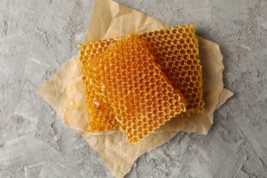 Gri zemin üzerinde bal peteği parçaları olan kağıt pişirme