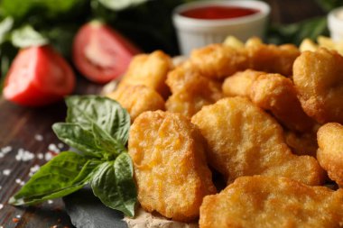 Tavuk nugget, sos ve ahşap arka planda patates kompozisyonu.