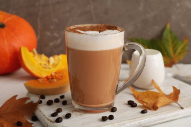 Beyaz arkaplanda cam bardak kabaklı latte ile kompozisyon