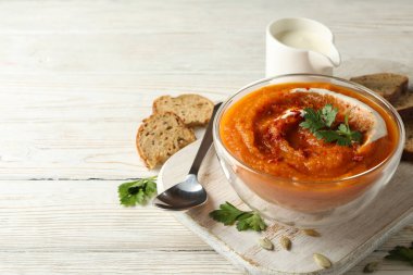 Beyaz ahşap zemin üzerinde balkabağı çorbası ile kompozisyon