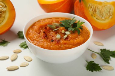 Beyaz arka planda bir kase kabak çorbası ile kompozisyon, kapat