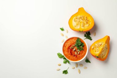 Beyaz arka planda bir kase kabak çorbası ile kompozisyon, üst görünüm