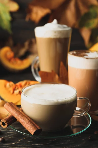 Composition with pumpkin latte, cinnamon and pumpkin on wooden background